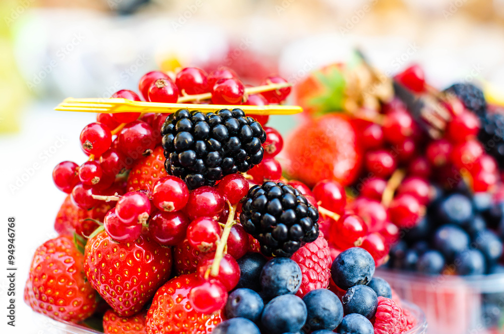 Forest fruits like a blueberries, raspberries, strawberries, red currants on a market. On a white tablecloth. Harvesting, agricultural market Forest fruits like a blueberries, raspberries, strawberries, red currants on a market. On a white tablecloth. Harvesting, agricultural market