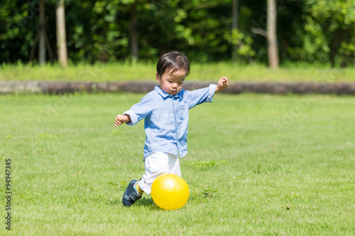Little boy playing soccer at park