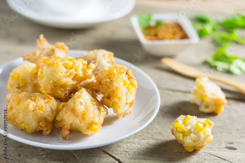 Crispy fried corn ball in a white plate on wooden table,Vegetari photo