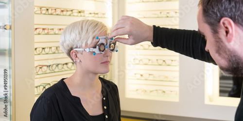 Optiker beim einstellen einer Testbrille bei einer Kundin photo