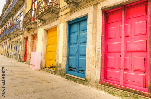 Colorful worn painted doors along street in Portugal - Artistic concept - Warm filter look © DisobeyArt