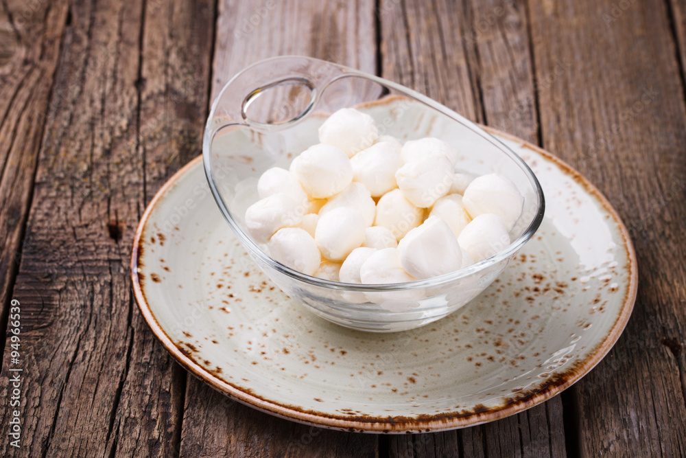 Round mini mozzarella in a glass bowl. selective focus Round mini mozzarella in a glass bowl. selective focus