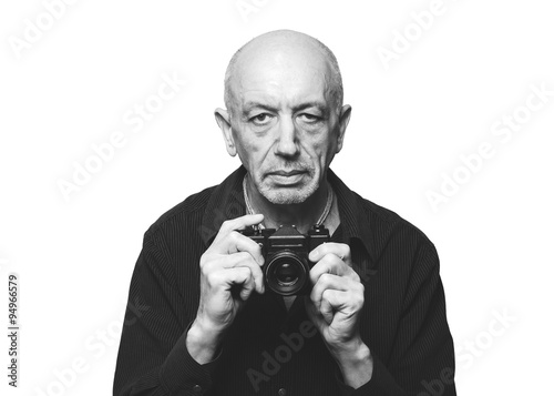 Senior, elderly man with old film camera on white background © kavzov