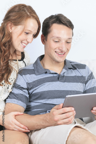 beautiful Couple on sofa with digital tablet