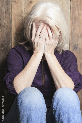 depress senior person with wood background