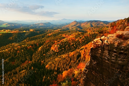 Autumn sunset in rocks. View over sandstone rocks to fall colorful valley of Bohemian Switzerland.