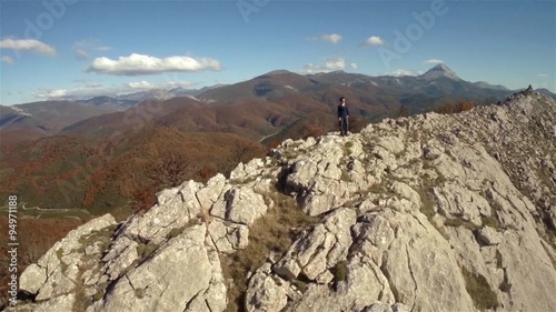 Aerial shot of a woman in the top of a rock mountain