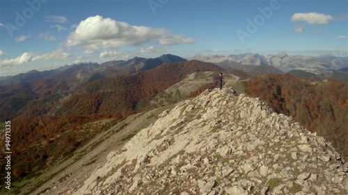 Aerial shot of a woman in the top of a rock mountain