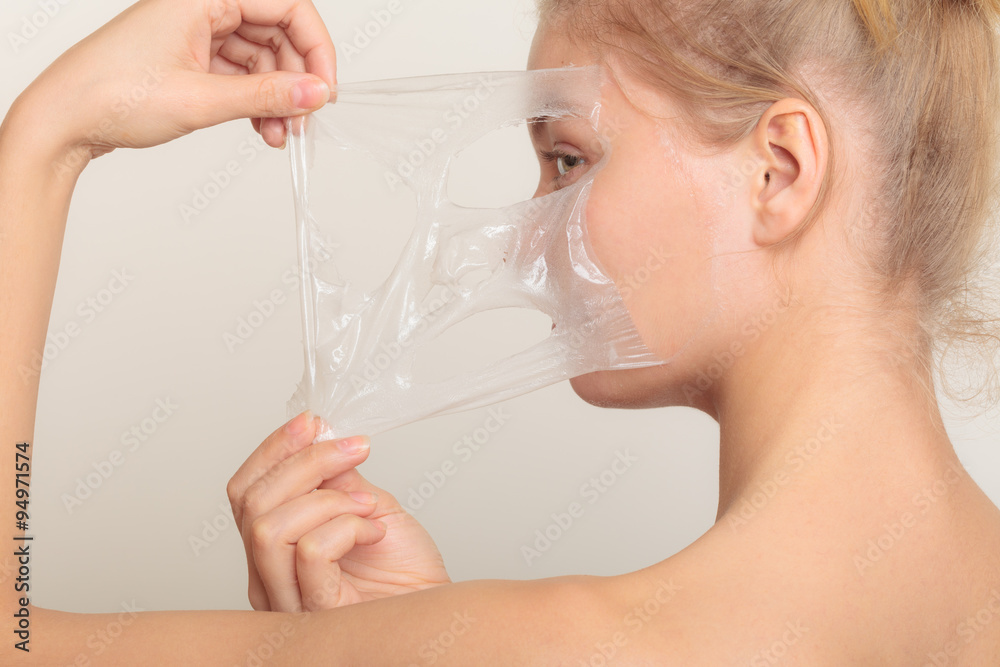 girl removing facial peel off mask