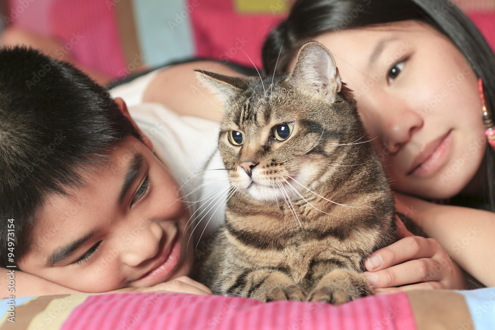 Asian kid lay on his bedroom with cat Asian kid lay on his bedroom with cat