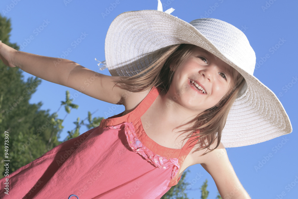 Little girl wearing a garden hat outdoors at the park