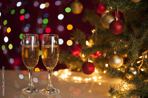 Two glasses of champagne near beautiful christmas tree 