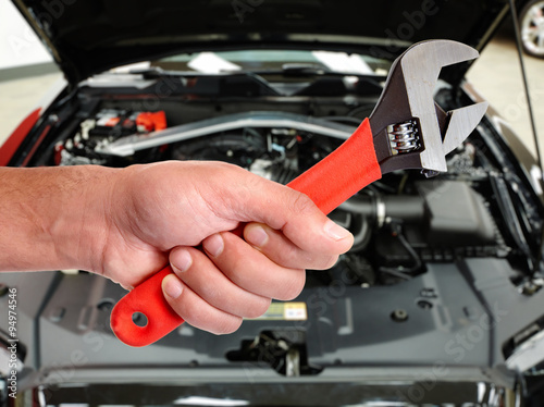 Hand of car mechanic in auto repair service. 