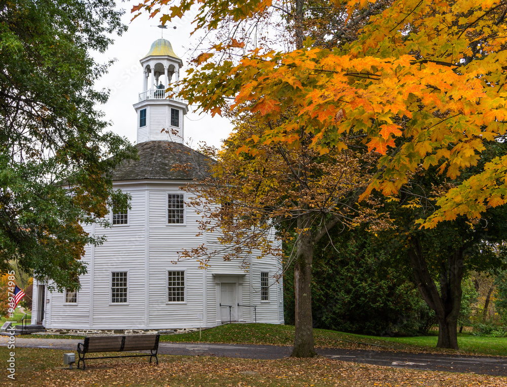 fall foliage frames the historic Round Church in Vermont village
