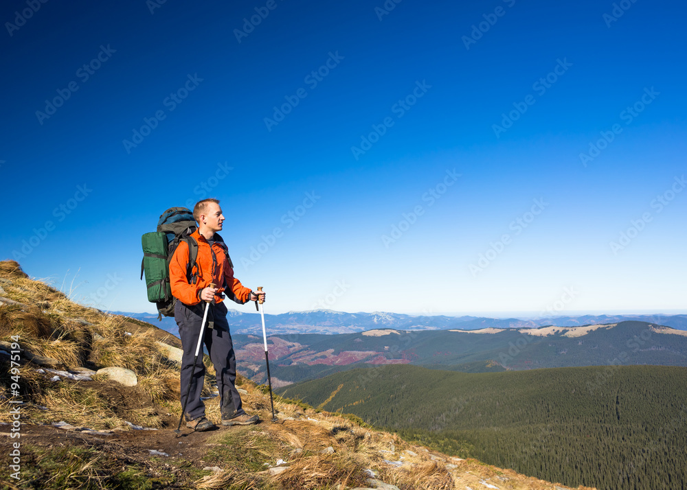 Man Traveler with Backpack hiking in Mountains with beautiful landscape