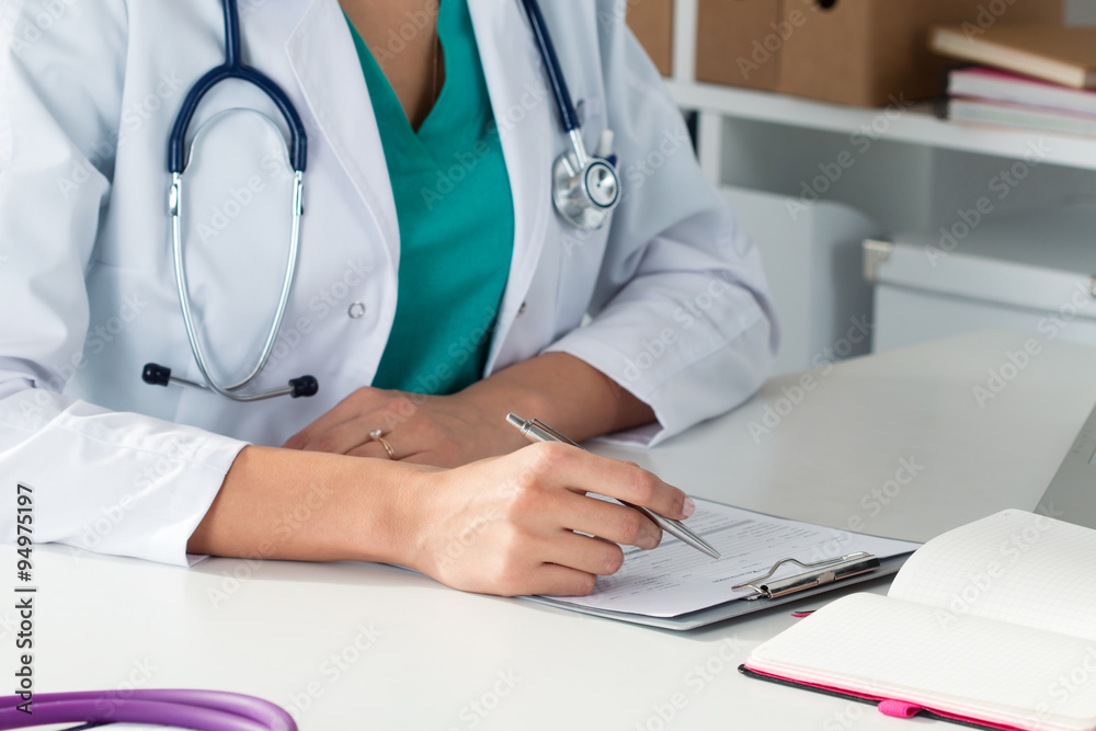 Close-up shot of female medical doctor's hands filling paient re