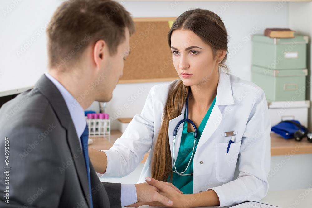 Friendly female medicine doctor's holding male patient's hand su Friendly female medicine doctor's holding male patient's hand su