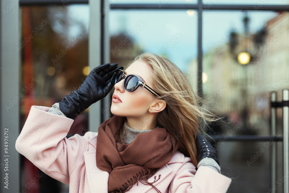 Fashion photo of beautiful young  woman with sunglasses. Model looking aside. City lifestyle. Female fashion. Closeup portrait. Beautiful reflection background 