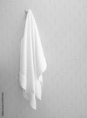 Soft white towel hanging in bathroom interior