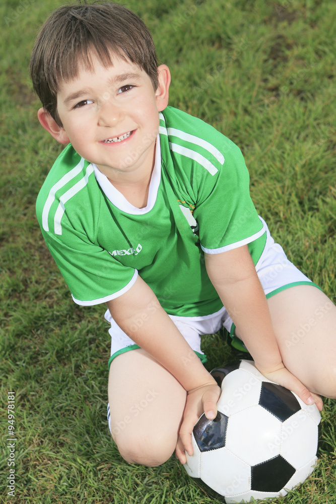 Obraz premium Kid play soccer on a field