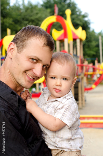 daddy holding his infant son outdoors