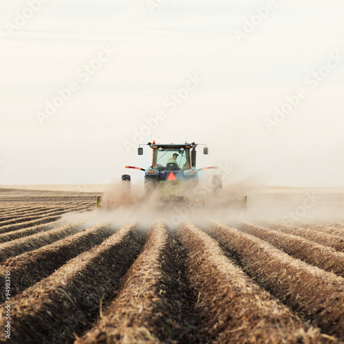 A tractor planting a potato crop on the prairies.