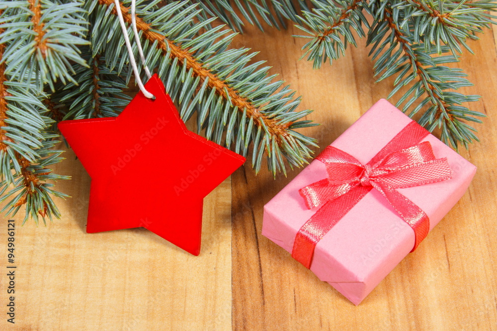 Spruce branches with red wooden star and gift for Christmas Spruce branches with red wooden star and gift for Christmas