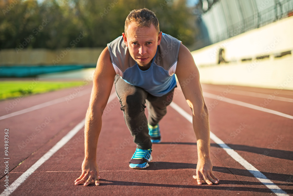 Athletic man standing in posture ready to run on a treadmill. Athletic man standing in posture ready to run on a treadmill.
