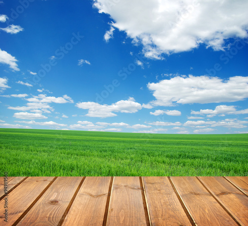  field under blue sky. Wood planks floor