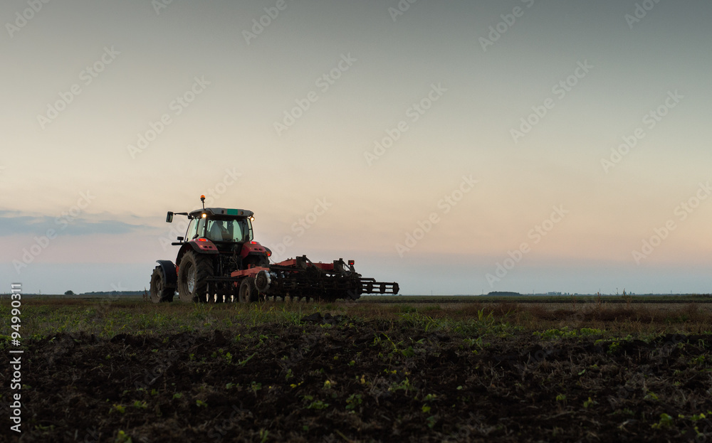 Fototapeta premium Tractor plowing a field