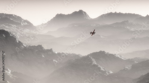 Misty mountain landscape at dawn with private airplane flying ov