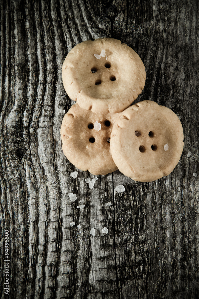 Cheese pastry shape like a button on old light grey wooden table Cheese pastry shape like a button on old light grey wooden table