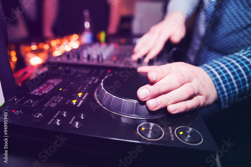 Club DJ playing mixing music on vinyl turntable