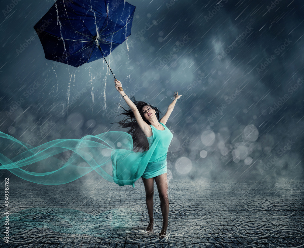 Junge Frau im Abendkleid tanzt im Regen StockFoto Adobe Stock