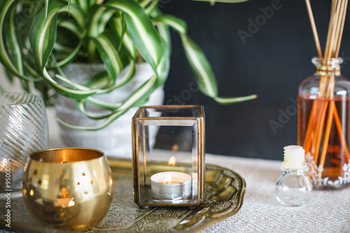 Vintage home decor: candles, aroma diffuser, plant and frames. Selective focus