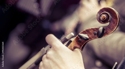 Violin and bow in the hands of the musician.