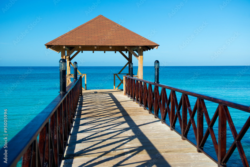 Wooden pontoon with canopy and with fence stretching into the sea Wooden pontoon with canopy and with fence stretching into the sea