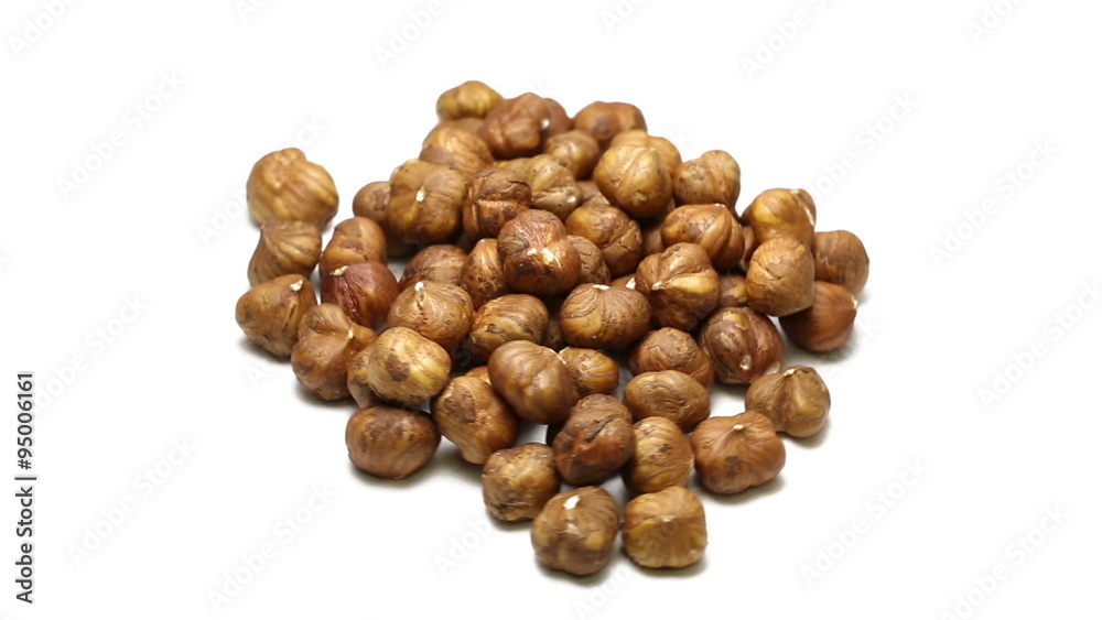 Pile of cracked and shelled hazelnut kernels rotating on white background Pile of cracked and shelled hazelnut kernels rotating on white background