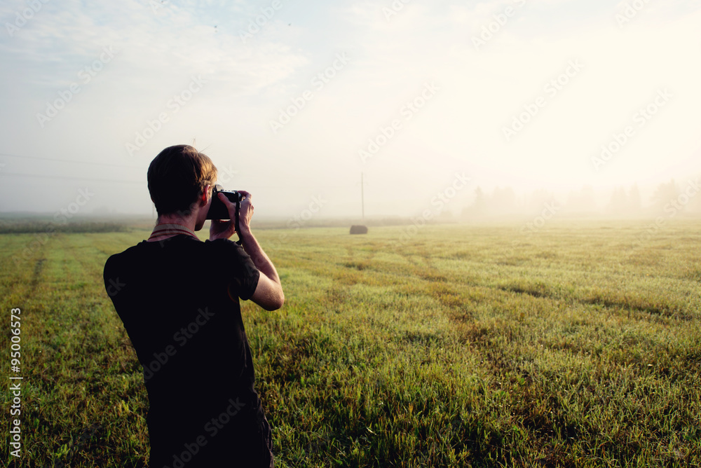 photographer in the fog taking a picture of the landscape photographer in the fog taking a picture of the landscape