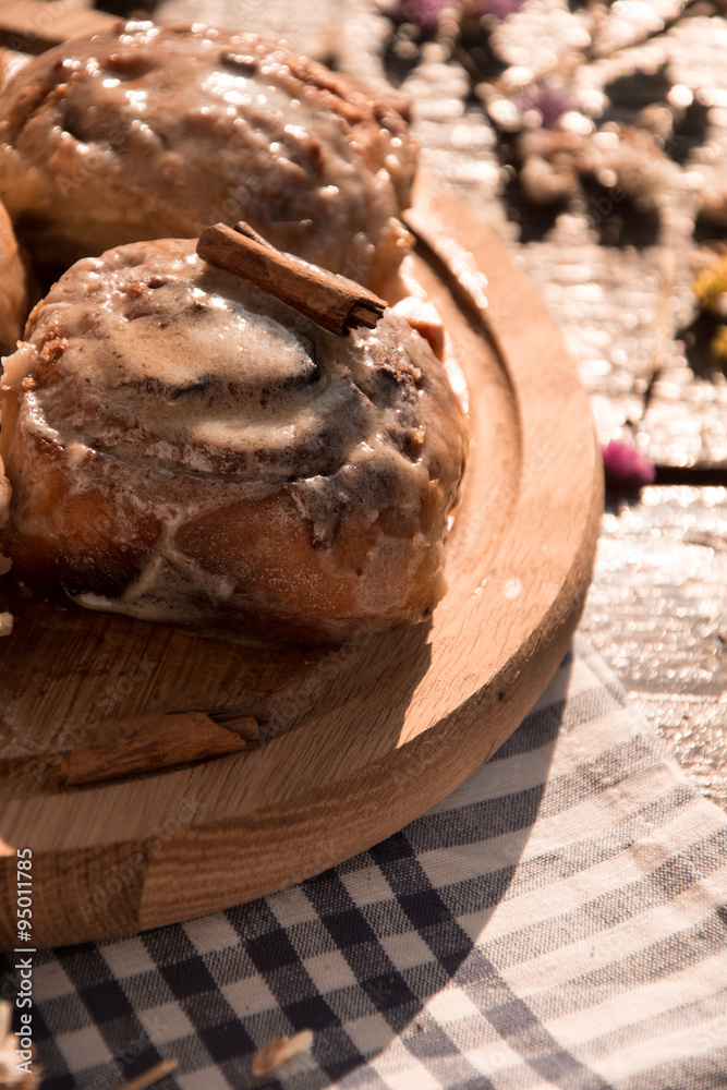 Cinnabon buns with cinnamon on a wooden board Cinnabon buns with cinnamon on a wooden board