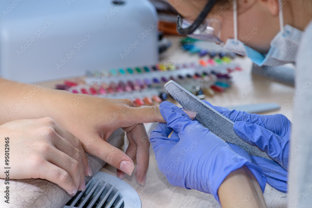 closeup of manicurist at work in the salon nail (shallow DOF; co
