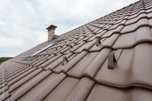 New roof with skylight, natural red tile and chimney with snow stopers photo