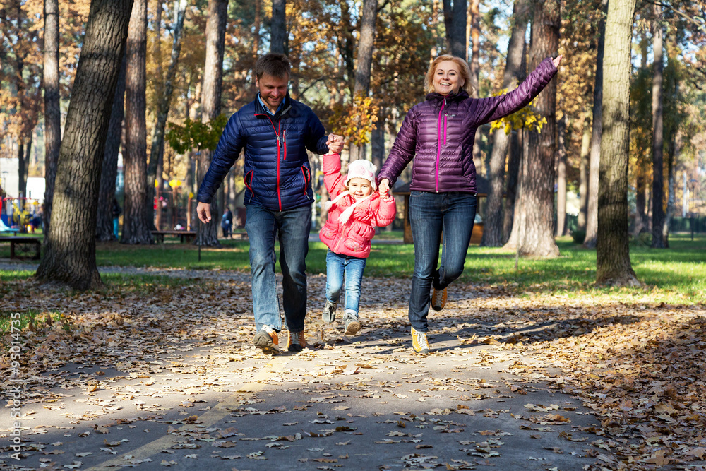 Young Family in Autumnal Forest Running Young Family in Autumnal Forest Running