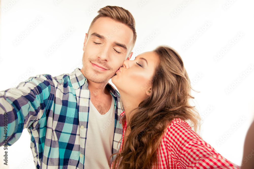 Happy pretty girl kissing her boyfriend making selfie Happy pretty girl kissing her boyfriend making selfie