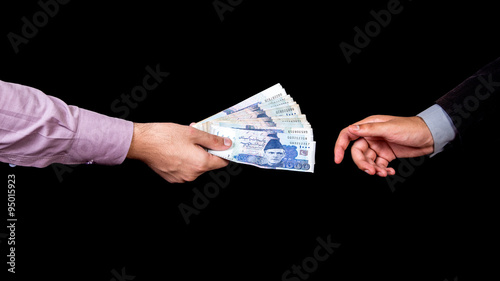Photos First person is giving 5000 Rupees Pakistani Currency Notes to another Person under the table