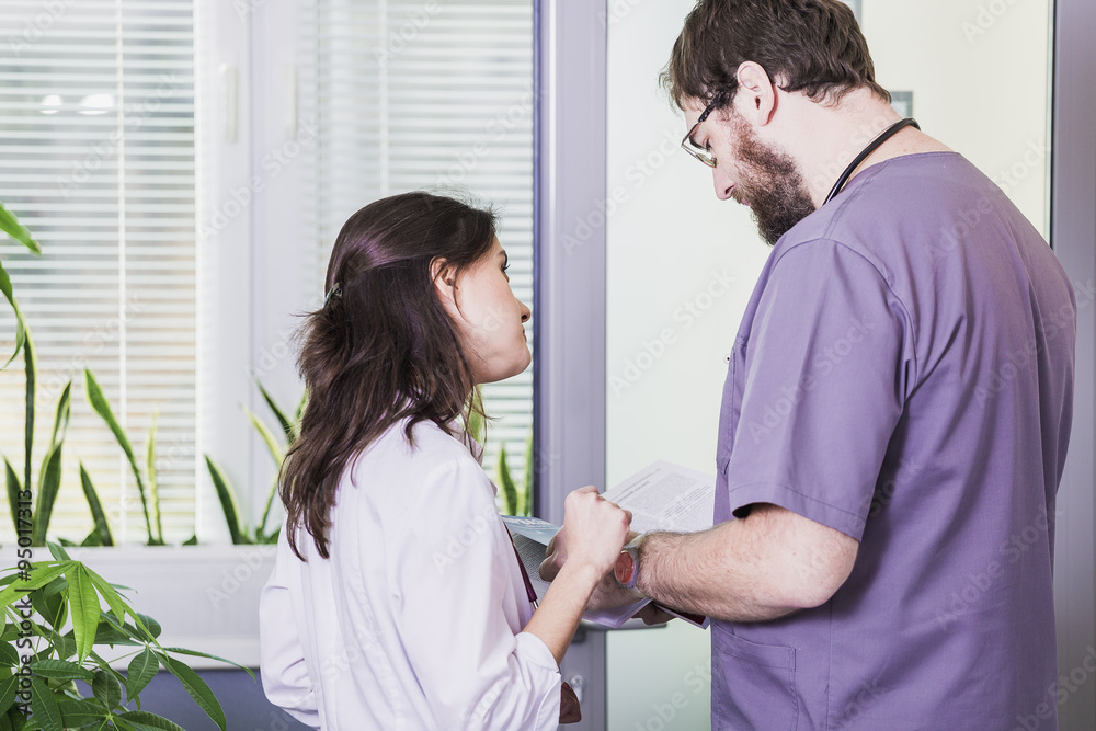 girl Doctor in a white coat with a stethoscope and male doctor with book girl Doctor in a white coat with a stethoscope and male doctor with book