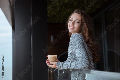 Woman standing on the balcony with coffee Free Download Woman standing on the balcony with coffee - GFXLoad