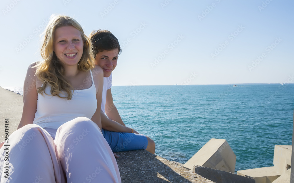 Smiling young couple in love relaxed beachfront