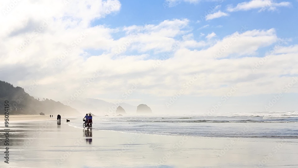 Young couple riding bikes along the Pacific coast