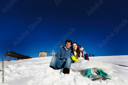 bride and groom in love siting on snow  on the background of the photo